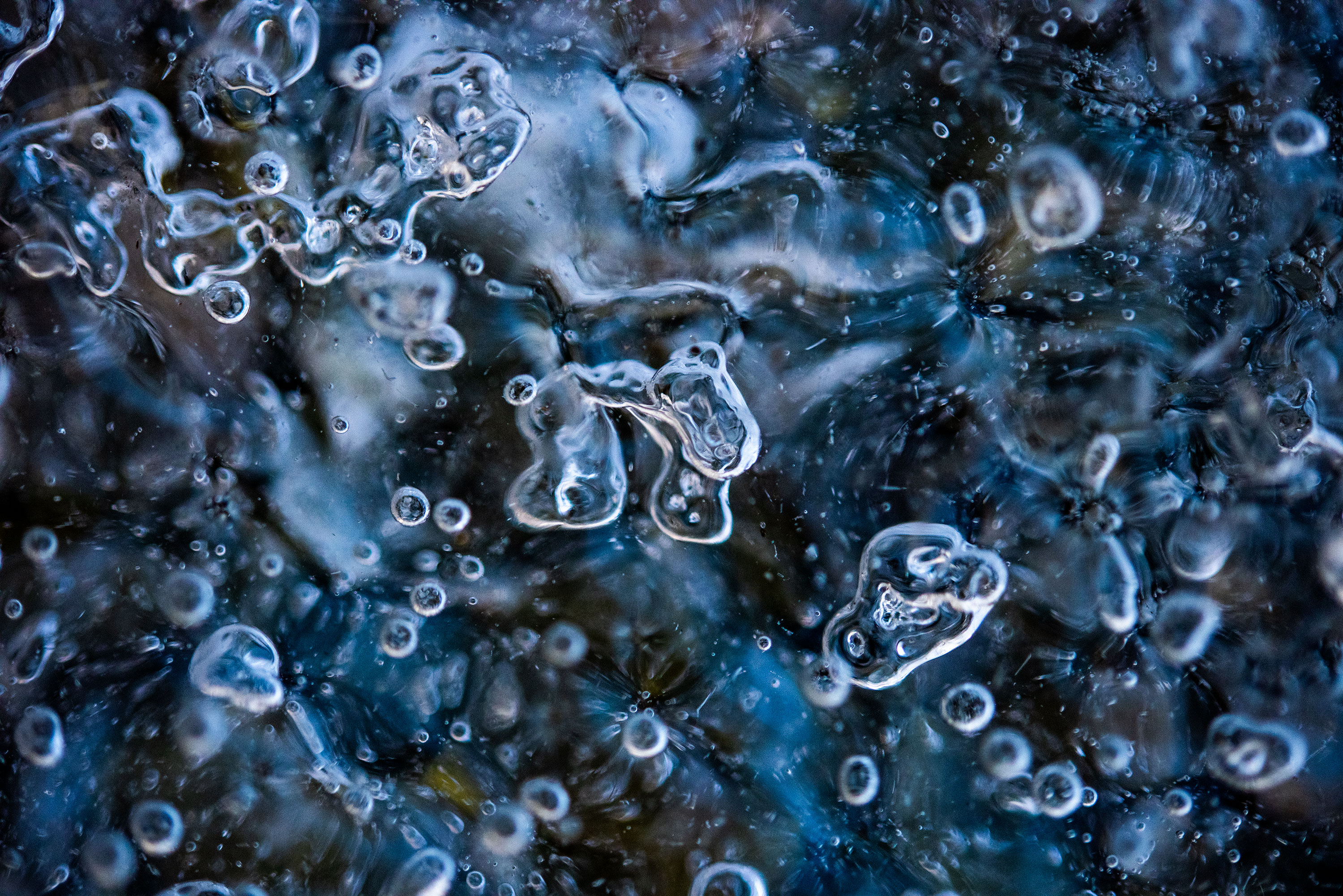 Macro photography of frozen water bubbles from a piece of ice hanging from a roof in Andermatt, Switzerland.
