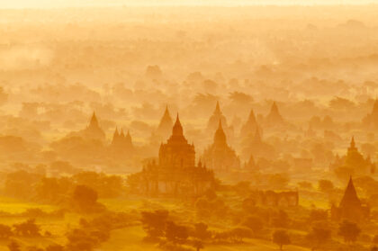 Behold the breathtaking beauty of Bagan and its iconic 1000 pagodas at sunrise, captured in this mesmerizing aerial photography. As the sun rises, casting a warm glow over the misty landscape, the silhouettes of the ancient pagodas emerge from the fog, creating a scene of unparalleled serenity and grandeur. From above, the vast expanse of Bagan's temple-strewn plains unfolds, offering a glimpse into the rich cultural heritage of Myanmar. Immerse yourself in the timeless allure of Bagan's sunrise vista, captured from a unique aerial perspective.