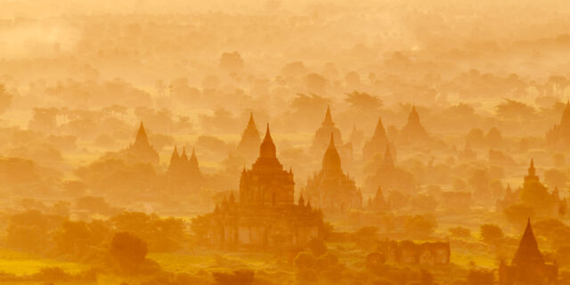 Behold the breathtaking beauty of Bagan and its iconic 1000 pagodas at sunrise, captured in this mesmerizing aerial photography. As the sun rises, casting a warm glow over the misty landscape, the silhouettes of the ancient pagodas emerge from the fog, creating a scene of unparalleled serenity and grandeur. From above, the vast expanse of Bagan's temple-strewn plains unfolds, offering a glimpse into the rich cultural heritage of Myanmar. Immerse yourself in the timeless allure of Bagan's sunrise vista, captured from a unique aerial perspective.