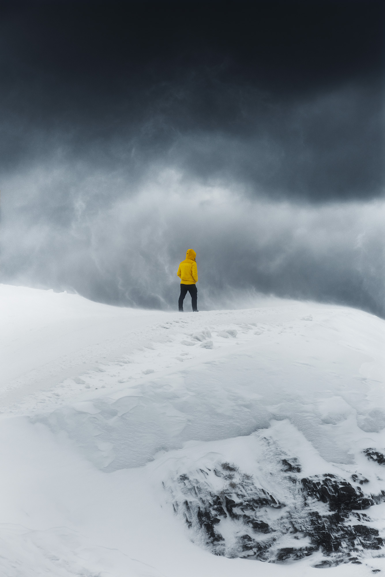 Swiss artist Jennifer Esseiva skillfully captures the essence of a winter snowstorm at Mesch-Fruttsee, Switzerland, through her lens with the Nikon Z8. In this striking landscape photograph, a lone figure clad in a vibrant yellow jacket stands resilient against the elements. Explore the artistry of nature in the hands of Jennifer's photography.