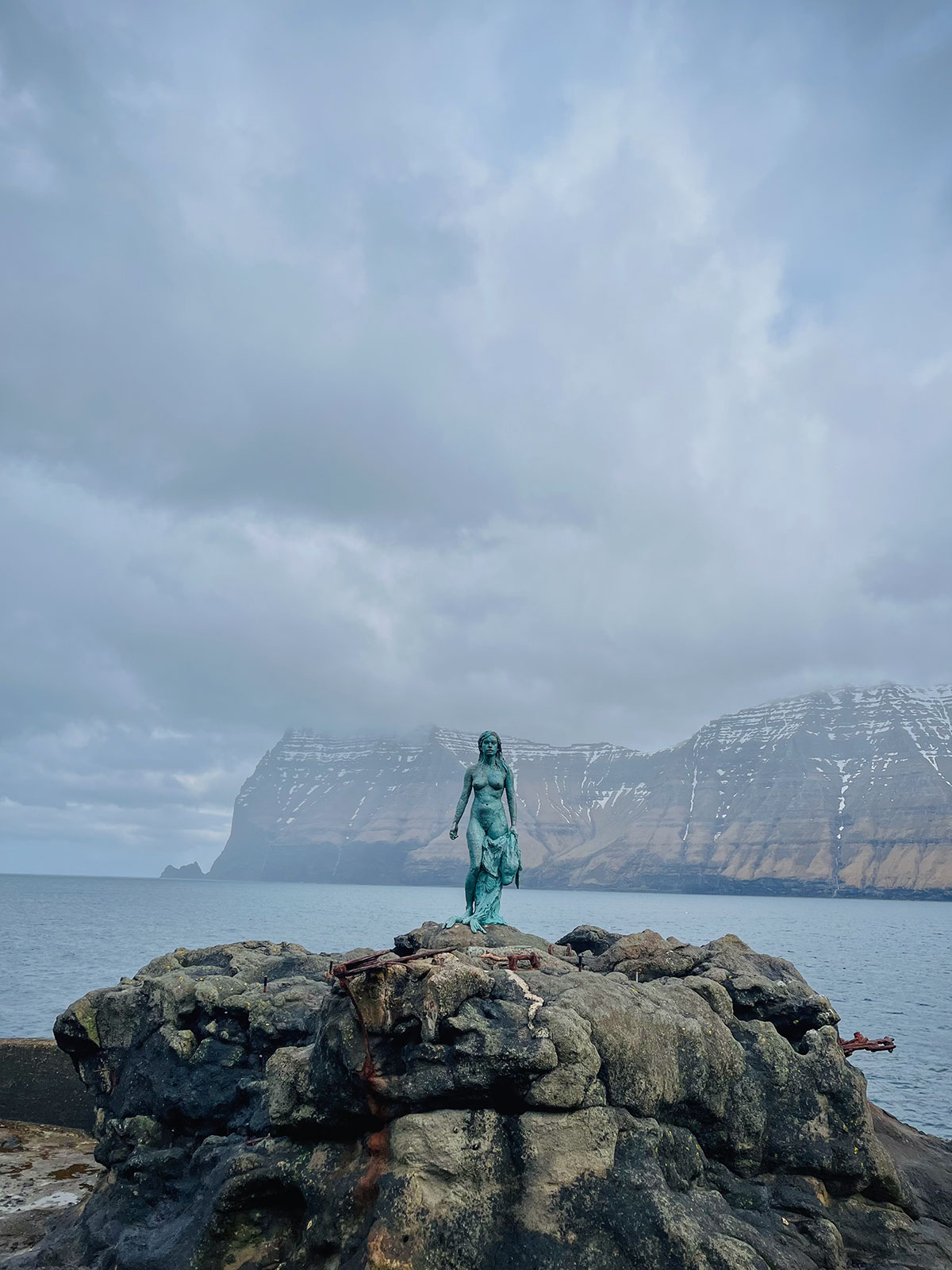 This image features the captivating Seal Lady sculpture on Kalsoy Island. Carved with meticulous detail, the Seal Lady gracefully emerges from the rugged landscape, paying homage to the rich maritime heritage of the Faroe Islands.