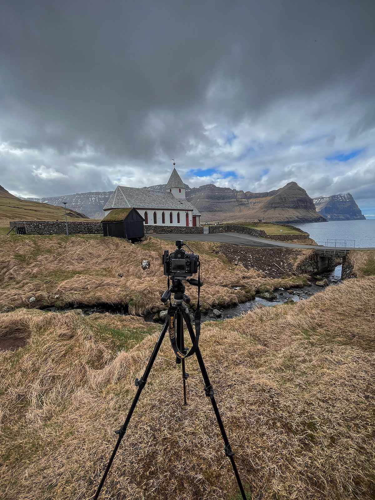 In this scene, my Nikon D810 becomes the storyteller, capturing the timeless beauty of the Church of Viðoy on a remote island in the Faroe archipelago. As the lens focuses on the church, the camera meticulously captures the architectural details against the backdrop of Viðoy's picturesque landscape.