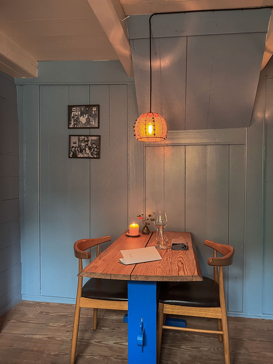 This inviting photograph provides a glimpse into the cozy ambiance of Restaurant Ræst in Tórshavn. The interior exudes a warm and welcoming atmosphere, with thoughtfully arranged tables and a play of soft lighting that enhances the dining experience.