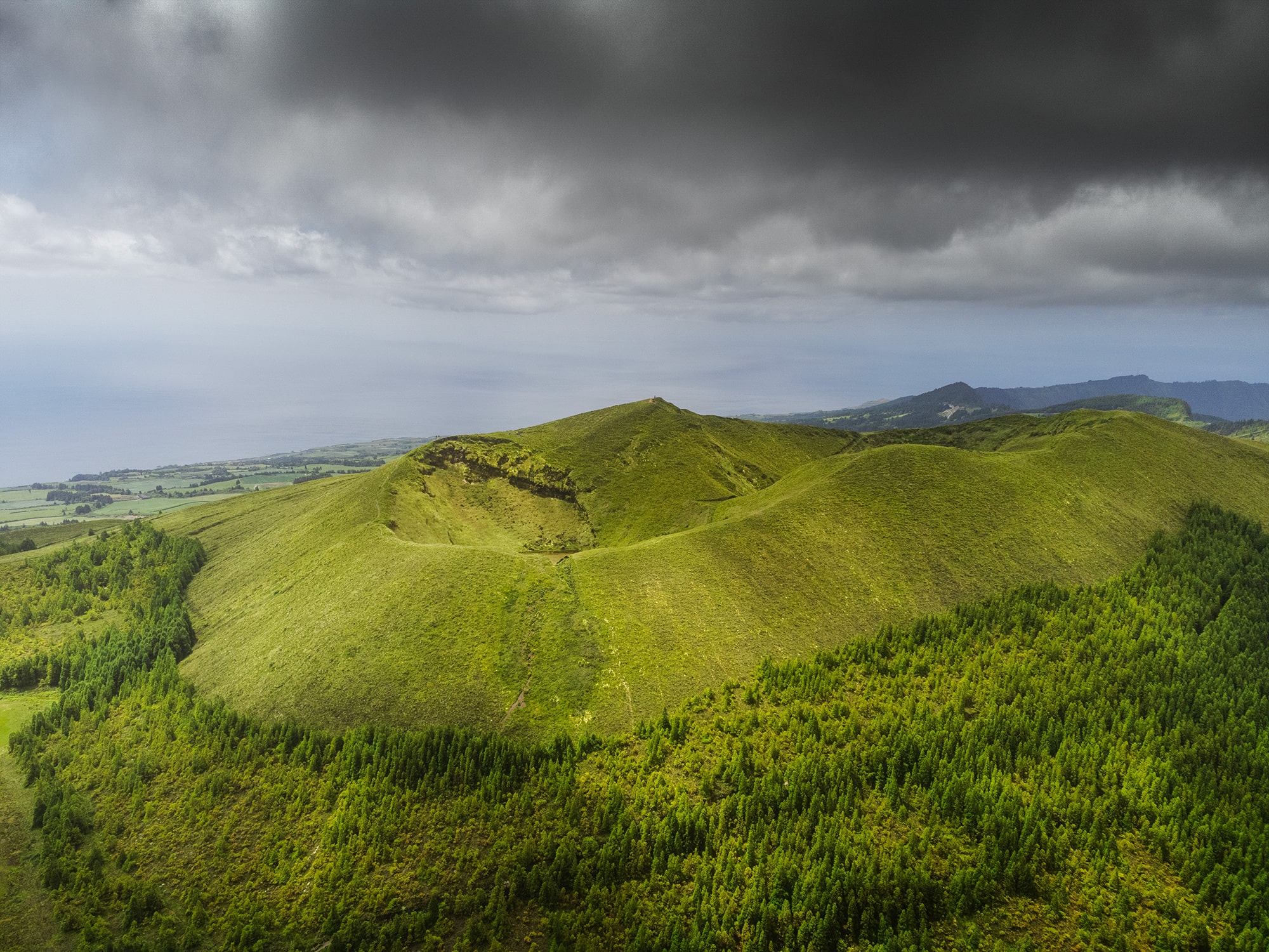 Embark on an aerial journey through the enchanting landscapes of São Miguel, Azores, with this captivating photography captured by Jennifer Esseiva and her DJI Mini 2 drone. Behold the majestic sight of a grass-covered volcano, its verdant slopes rising gracefully against the azure sky. From above, the intricate details of nature's canvas unfold, showcasing the timeless beauty of this volcanic island. Join Esseiva on this visual odyssey as she unveils the breathtaking landscapes of São Miguel, where every frame captures the unique charm and natural allure of the Azores from a bird's-eye perspective.