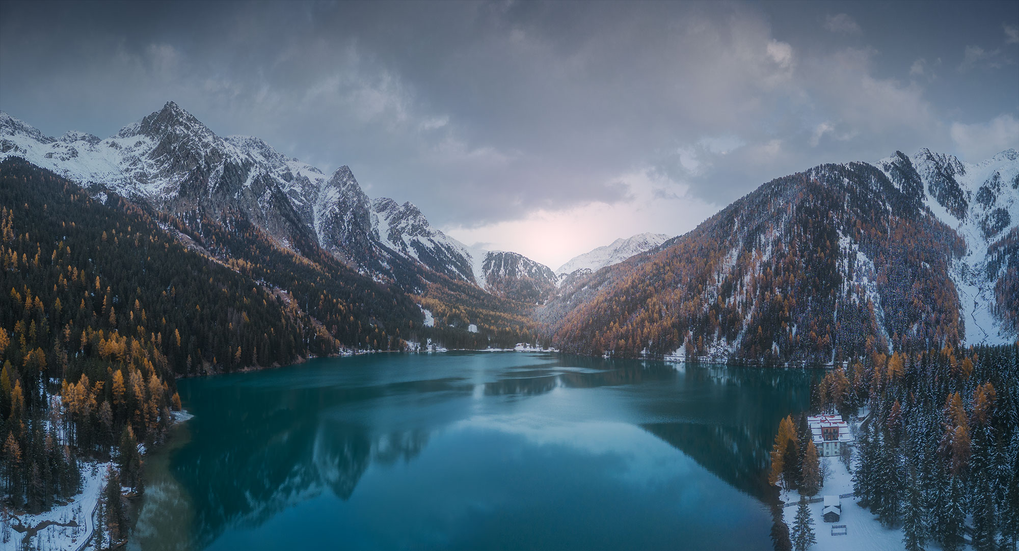 Unlock a bird's eye view of the mesmerizing Anterselva lake in Italy's Dolomites through stunning drone photography. Expertly captured by acclaimed landscape photographer Jennifer Esseiva using her DJI Mini 2, this aerial imagery offers a breathtaking perspective of the serene landscape below. As the sun sets over the majestic peaks of the Dolomites, hues of orange and gold paint the sky in a mesmerizing display of nature's beauty. Immerse yourself in the tranquility of the Italian Alps with Jennifer Esseiva's captivating drone photography, and experience the magic of sunset in the Dolomites from a whole new angle. Explore the exquisite details of this iconic landscape, captured with precision and artistry, and let the beauty of Italy's natural wonders leave you spellbound.