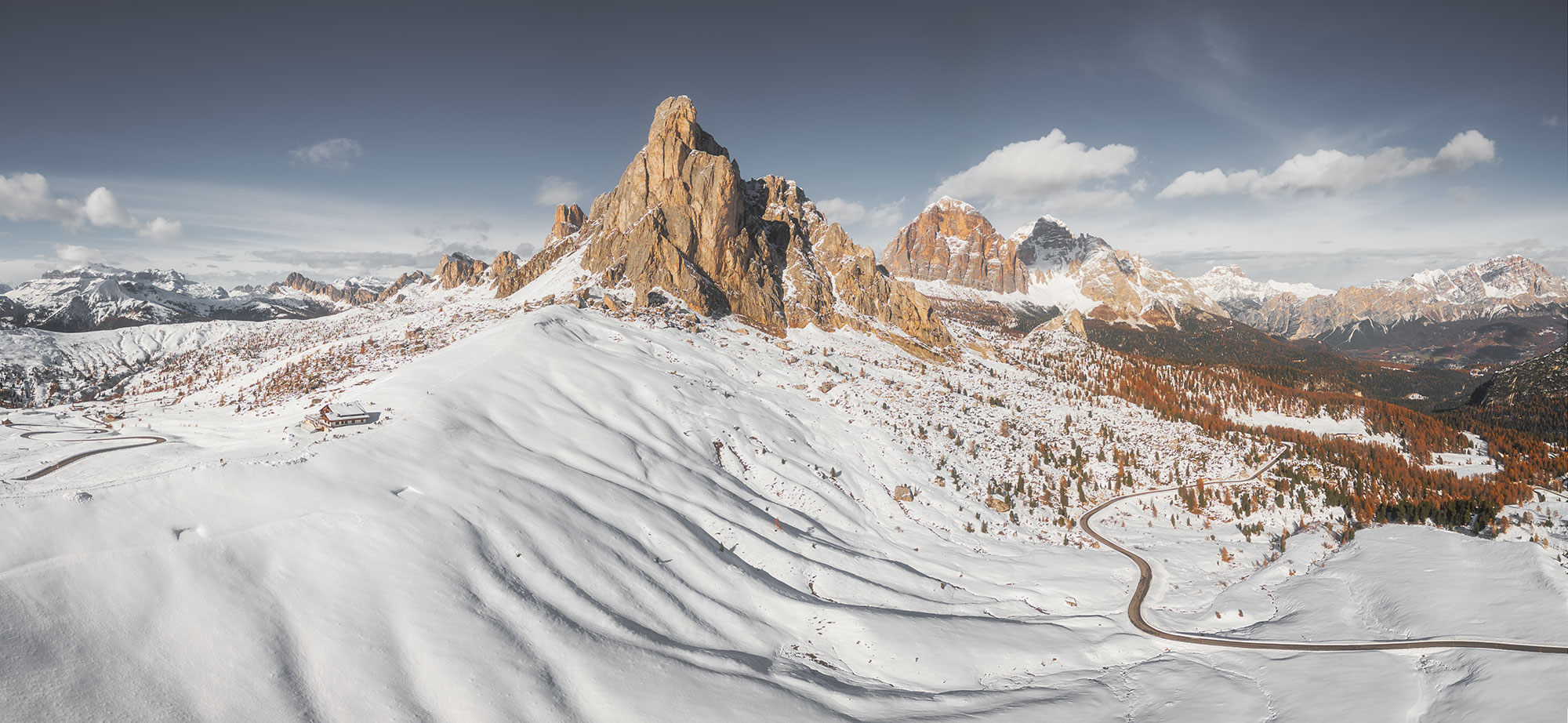 Behold the breathtaking panorama captured by landscape photographer Jennifer Esseiva, showcasing the majestic Ra Gusela mountains as they tower over the Passo Giau in the Dolomites. This mesmerizing image depicts the rugged beauty of the peaks bathed in the warm glow of a sunset, casting a golden hue across the landscape. With her skilled eye and Nikon D810 camera in hand, Jennifer Esseiva has immortalized this stunning moment, inviting viewers to immerse themselves in the tranquil majesty of the Dolomites at twilight.