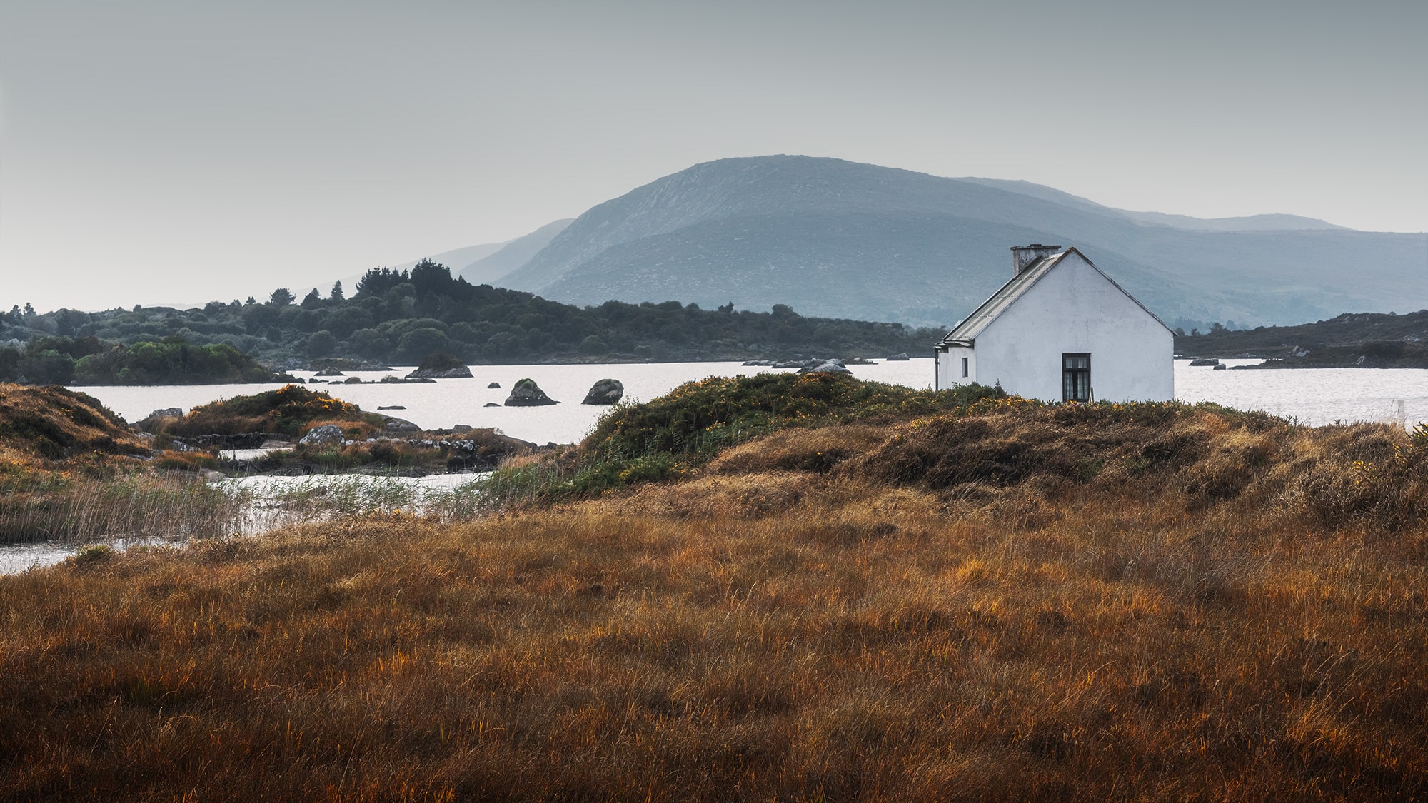 Step into the timeless charm of Connemara, near Galway in Ireland, through this captivating landscape photography captured by Swiss photographer Jennifer Esseiva and her Nikon D810. Behold the rustic beauty of a traditional fisherman's cottage nestled amidst the wild nature and rugged landscape of Connemara. With its wide-angle perspective, this photograph invites you to immerse yourself in the raw, untamed beauty of the Irish countryside. Join Jennifer Esseiva on this visual journey as she captures the essence of Connemara, where every detail tells a story of tradition, resilience, and the enduring allure of the natural world.
