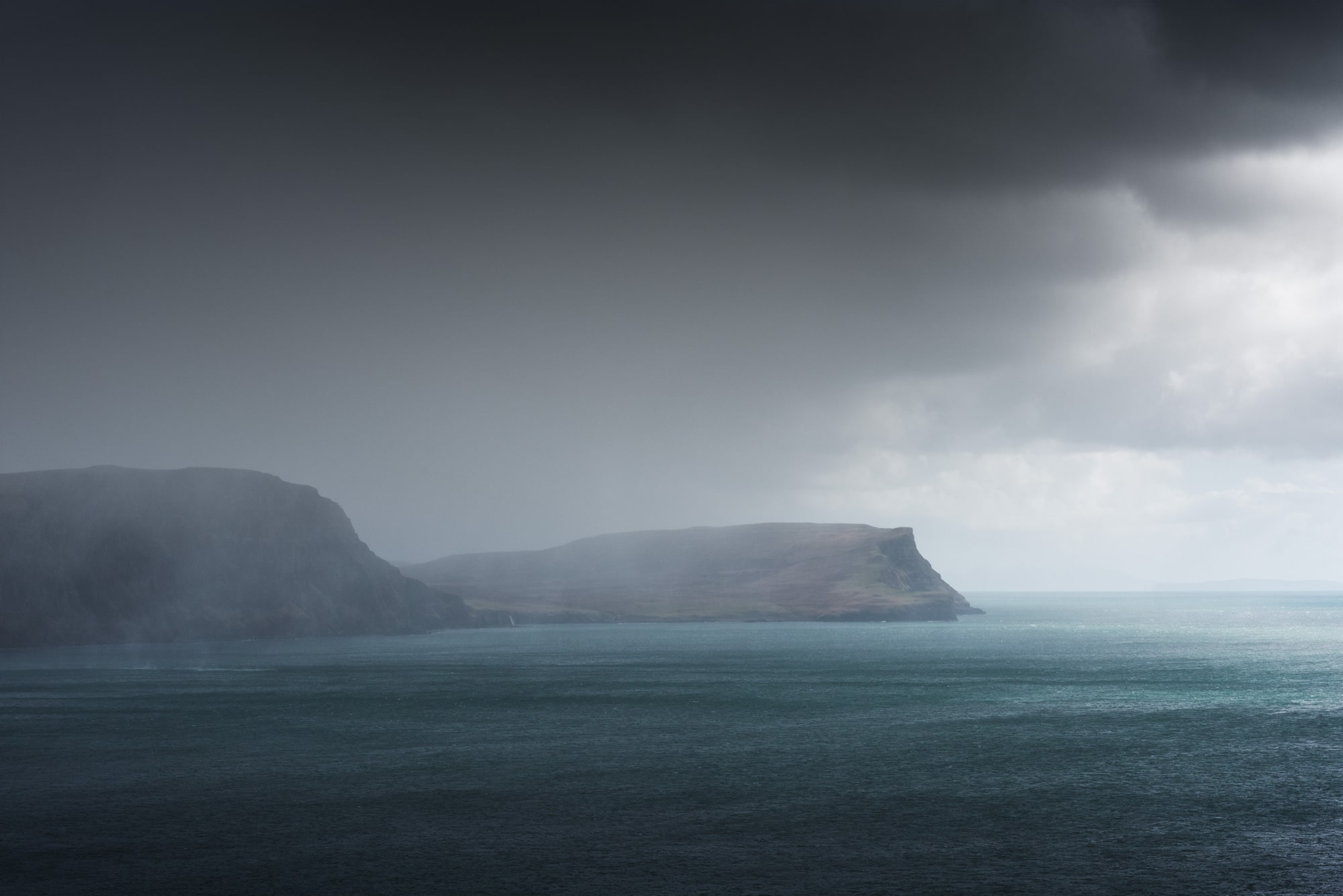 Experience the raw beauty of Skye Island's rugged coastline in Scotland with this captivating landscape photography captured by Swiss photographer Jennifer Esseiva and her Nikon D810. Witness the power of nature as a rainstorm sweeps across the coastal landscape, casting an ethereal veil over the land and sea. Jennifer Esseiva's skilled eye captures the dynamic interplay of light and shadow, evoking a sense of drama and majesty in the midst of the storm. Join Esseiva on this visual journey through the untamed landscapes of Skye Island, where every frame tells a story of resilience and the timeless allure of the Scottish wilderness.