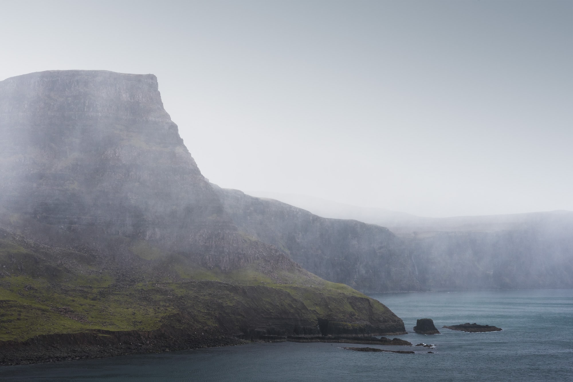 Immerse yourself in the raw beauty of the Scottish coast with this captivating landscape photography captured by Swiss photographer Jennifer Esseiva and her Nikon D810. Behold the dramatic scene of a rainstorm sweeping over Waterstein Head, near Neist Point, on Skye Island. Jennifer Esseiva's expert composition and keen eye for detail bring to life the dynamic atmosphere of the moment, as dark clouds loom overhead and rain cascades down the rugged cliffs. Join Esseiva on this visual journey through the untamed landscapes of Skye Island, where every frame tells a story of nature's power and the enduring allure of the Scottish wilderness.