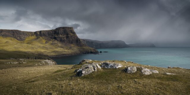 Rainstorm over Waterstein Head near Neist Point, Isle of Skye, Scotland, with dramatic clouds and rugged cliffs.