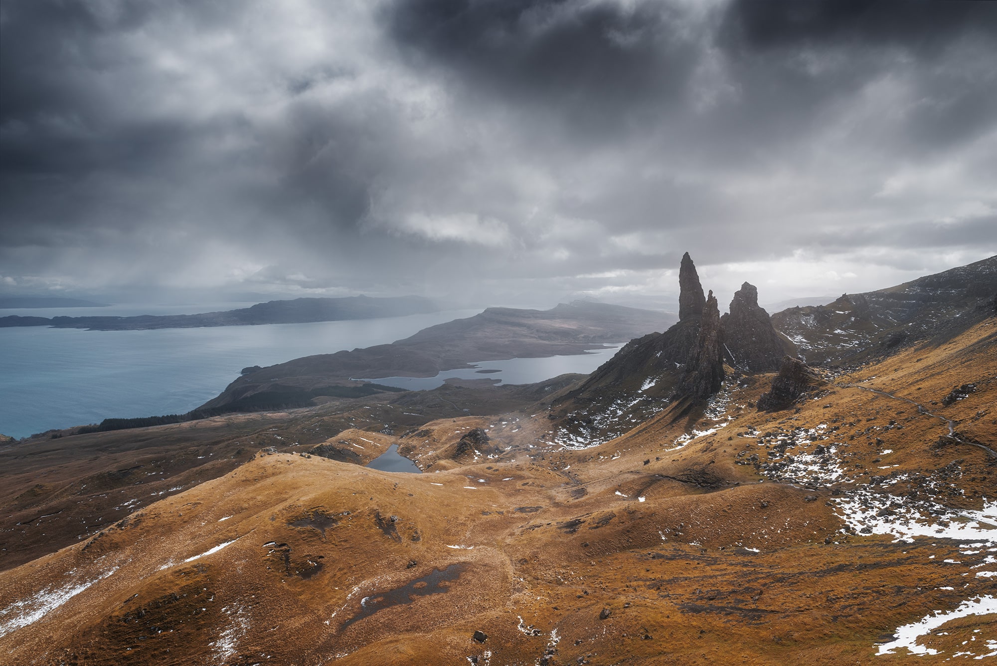Experience the awe-inspiring grandeur of Skye Island, Scotland, with this epic landscape photography captured by Swiss photographer Jennifer Esseiva and her Nikon D810. Behold the iconic silhouette of the Old Man of Storr against a backdrop of dramatic skies, as Jennifer Esseiva masterfully captures the timeless beauty of this rugged landscape. The towering rock formations and swirling clouds evoke a sense of ancient mystique and untamed wilderness, inviting viewers to embark on a visual journey through the heart of the Scottish Highlands. Join Esseiva on this extraordinary adventure where every frame tells a story of nature's raw power and breathtaking beauty.