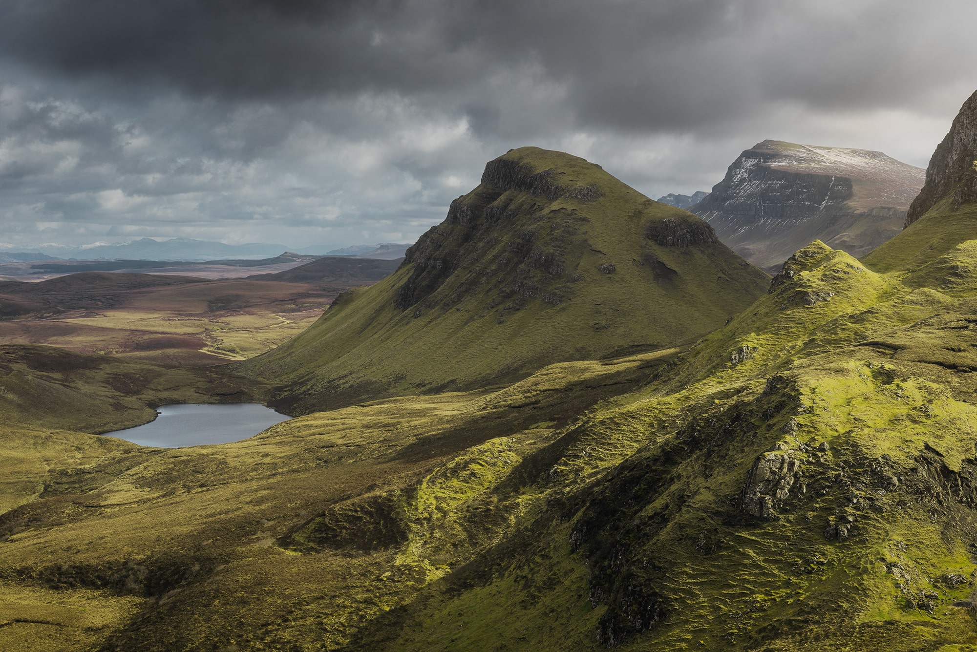 Embark on a visual odyssey through the stunning landscapes of Skye Island, Scotland, with this epic green landscape photography captured by Swiss photographer Jennifer Esseiva and her Nikon D810. Behold the breathtaking majesty of the Quiraing, where rolling green hills meet towering cliffs under a dramatic sky. Esseiva's expert eye for composition and mastery of light capture the raw beauty and untamed wilderness of this iconic location. Join Jennifer Esseiva on this extraordinary journey where every frame tells a story of nature's grandeur and the timeless allure of the Scottish Highlands.
