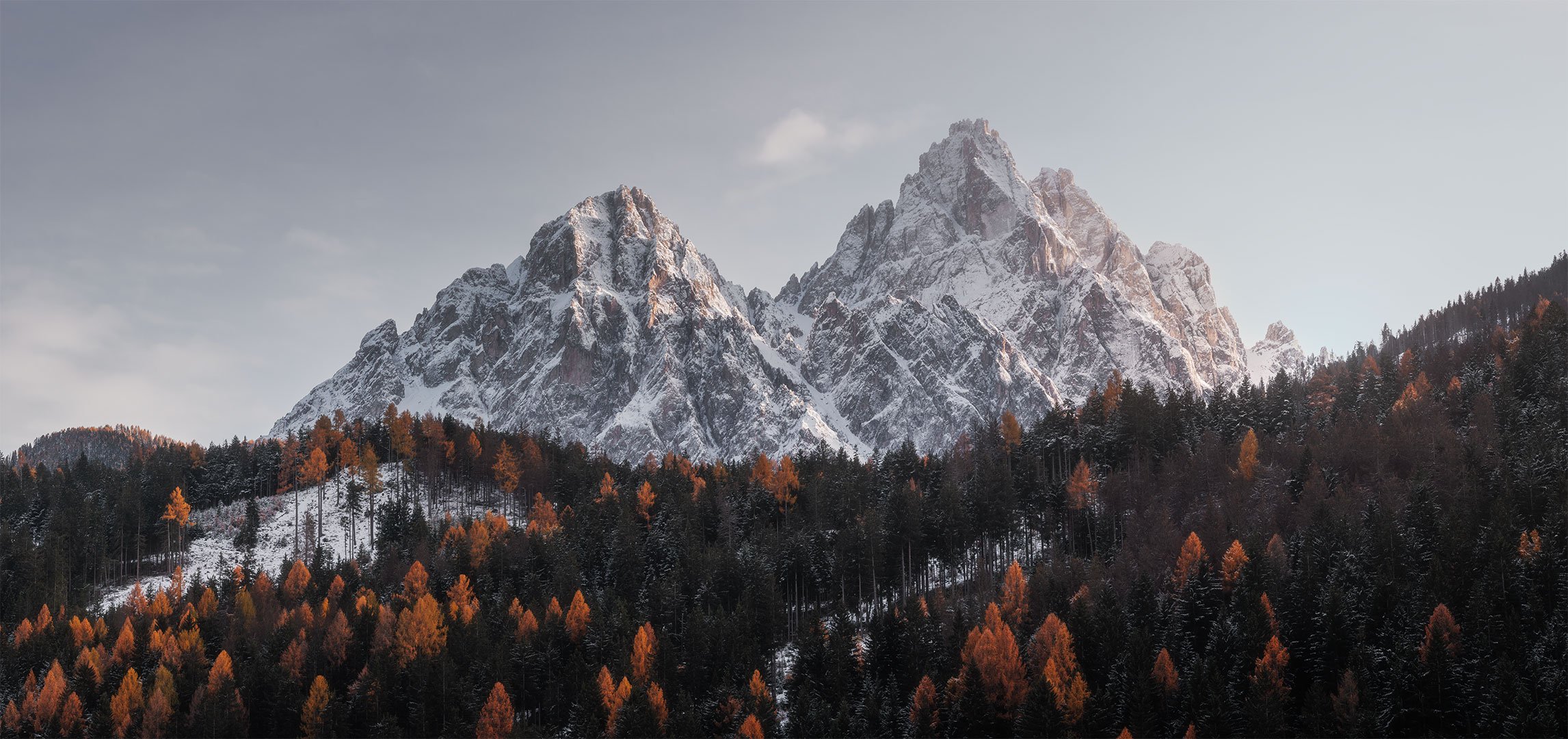 Capture the awe-inspiring beauty of the Dolomites in Italy with this stunning landscape photograph taken by Jennifer Esseiva using her trusty Nikon D810 camera. The image showcases a panoramic view of the majestic mountains, bathed in the warm hues of a breathtaking sunset. Each peak is silhouetted against the vibrant sky, creating a scene of unparalleled natural splendor. This captivating landscape photograph exemplifies the beauty of the Dolomites and highlights Jennifer Esseiva's talent for capturing the essence of this iconic location through her lens.