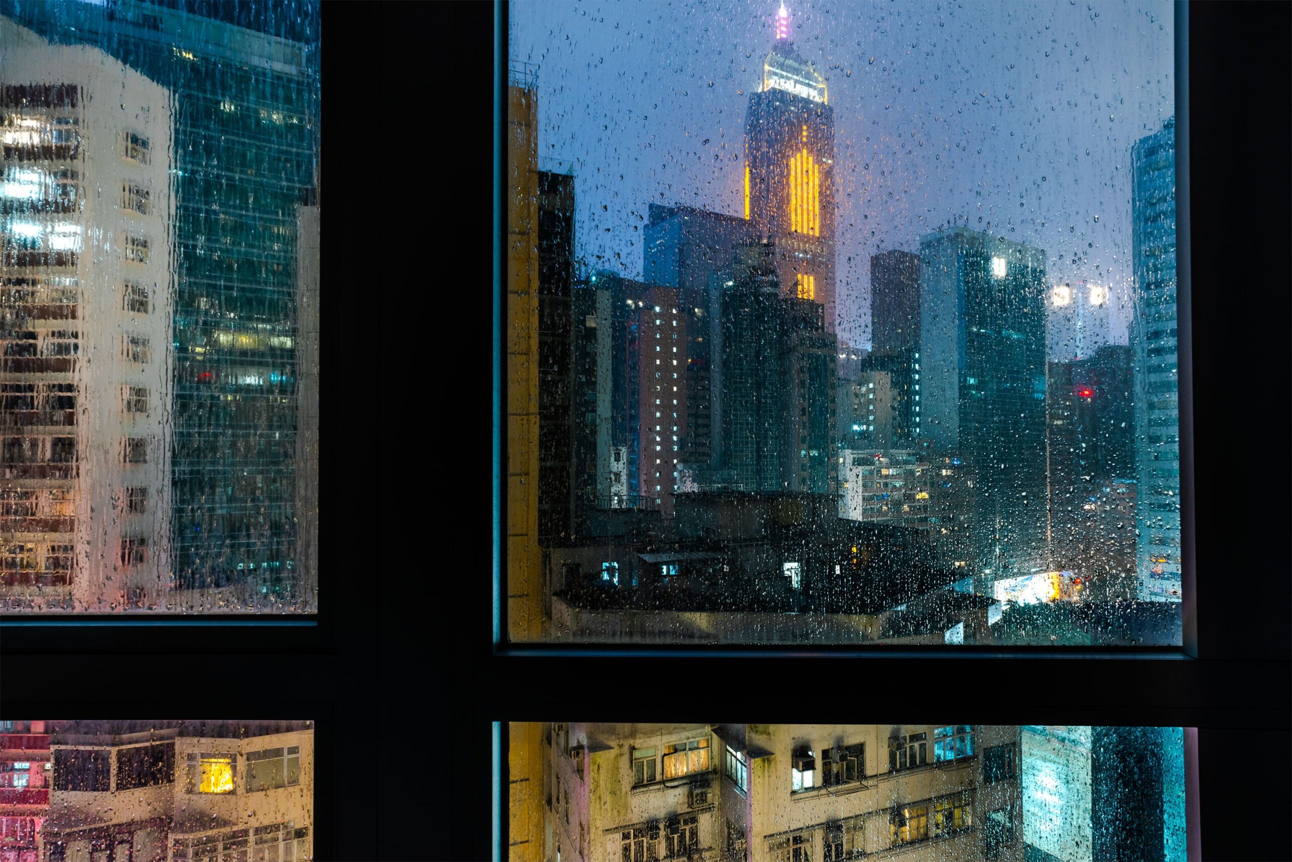 Behold the dramatic night view over Hong Kong from the 40th floor amidst a raging typhoon and thunderstorm. This urban landscape photograph captures the electrifying energy of the cityscape as it braves the elements of nature. With the skyline illuminated by flashes of lightning and the tumultuous clouds swirling overhead, the scene exudes an intense and awe-inspiring atmosphere. A testament to the resilience and vibrancy of urban life in Asia, this captivating image offers a glimpse into the raw power and beauty of nature's fury against the backdrop of a bustling metropolis.