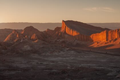 Sunset over Valle de la Luna near San Pedro de Atacama, Chile, with dramatic desert silhouettes and warm evening light.