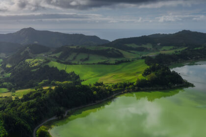 Aerial view of Lagoa das Furnas in São Miguel, Azores, with emerald green water and lush surrounding vegetation.