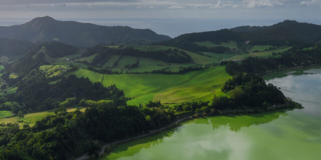 Aerial view of Lagoa das Furnas in São Miguel, Azores, with emerald green water and lush surrounding vegetation.