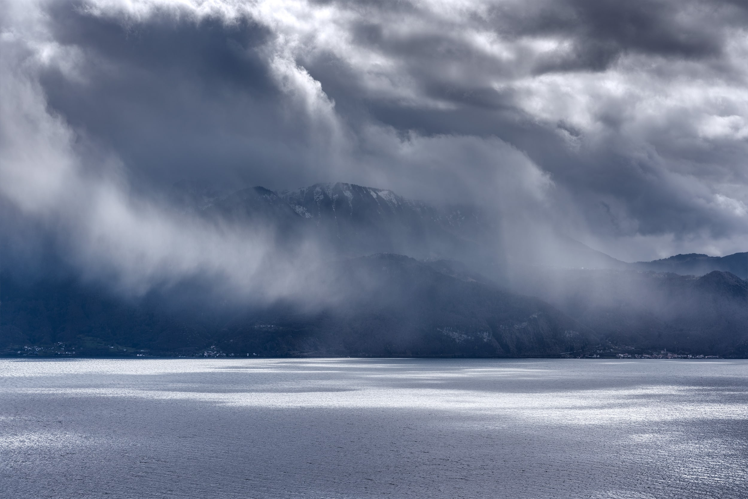 Experience the captivating drama of a rainy day at Lavaux Vineyard Terrace in Switzerland, beautifully captured in landscape photography by Jennifer Esseiva using her Nikon D810. This striking image immerses viewers in the unique ambiance and natural splendor of the Swiss countryside. Explore the dynamic contrast between light and shadow, as well as the rich textures of the landscape, in Jennifer's stunning portfolio of landscape photography.