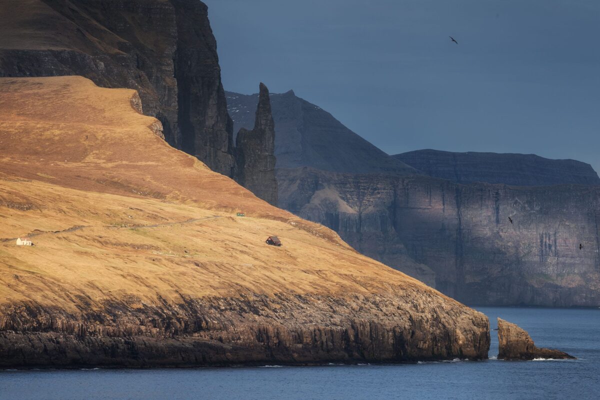 Trøllkonufingur rock formation in the Faroe Islands, with rugged coastal cliffs and ocean below.