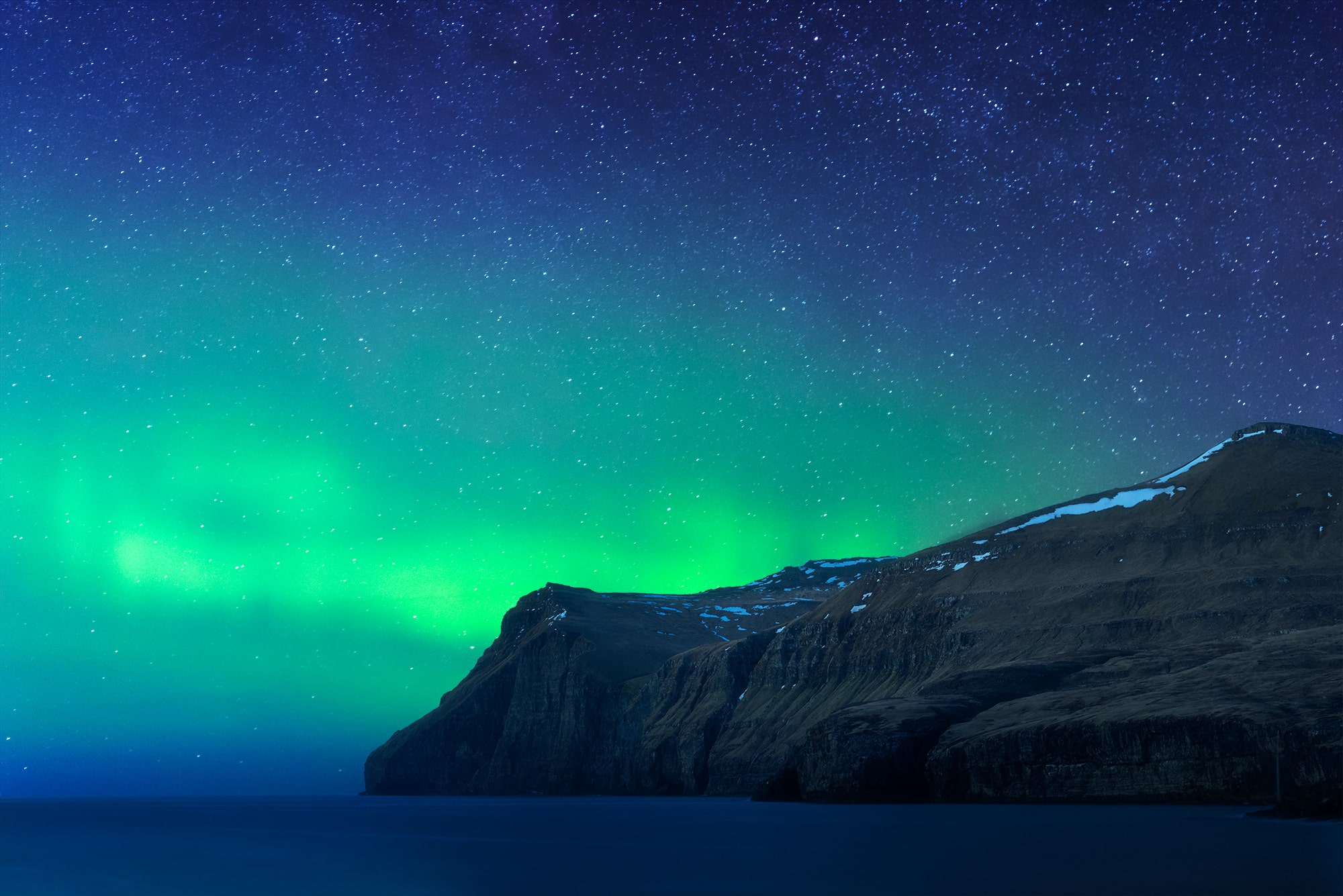 Experience the awe-inspiring beauty of astrophotography with this captivating image capturing the Aurora Borealis dancing above the sea, taken in the charming village of Eidi in the Faroe Islands. Witness the celestial spectacle as vibrant hues illuminate the night sky, painting a mesmerizing scene against the backdrop of the tranquil waters. Immerse yourself in the magic of the Northern Lights captured in this stunning composition.