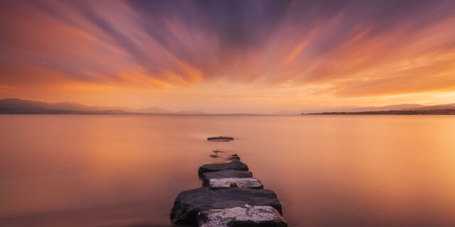 Journey through the captivating lens of Swiss photographer Jennifer Esseiva as she unveils the magical allure of a pink sunset over Lake Geneva from Préverenges Beach. With a mastery of her craft, Jennifer employs 3-minute long exposures to craft an exquisite watercolor mood that transcends the ordinary. Immerse yourself in the breathtaking beauty of Switzerland, where every frame is a testament to Jennifer's artistry in capturing the sublime.