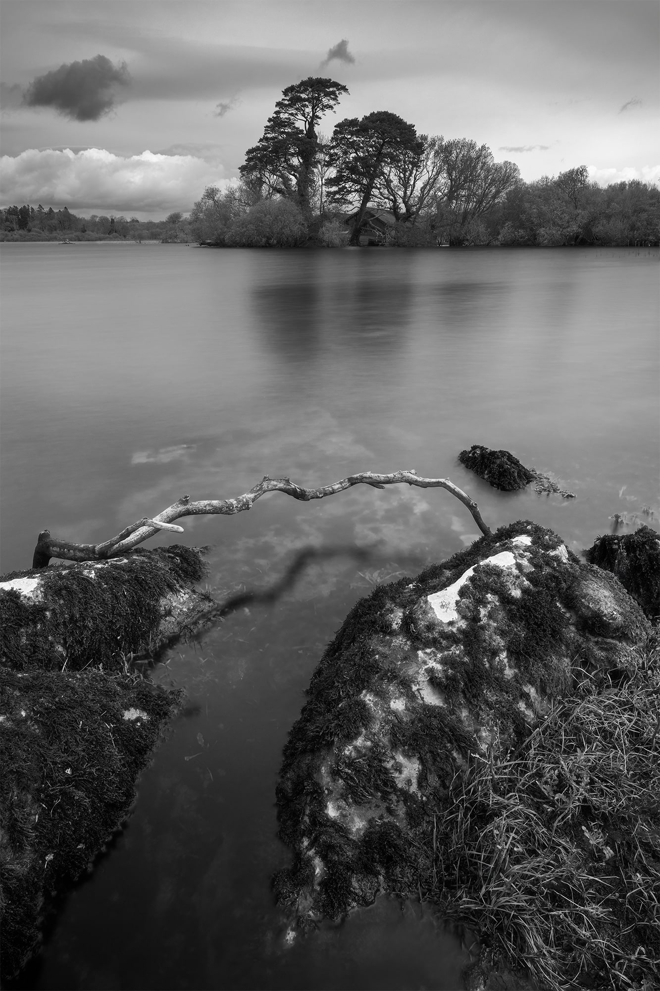 Black and white landscape photograph of the serene lakes of Killarney in Ireland. Captured with a long exposure technique using a Nikon Z8 camera, this stunning image showcases the timeless beauty of the Irish landscape.
