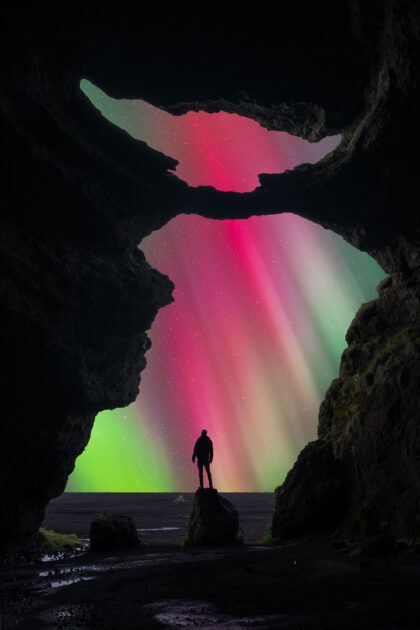 Northern lights at Yoda Cave, Iceland, with aurora illuminating cave opening and night sky.