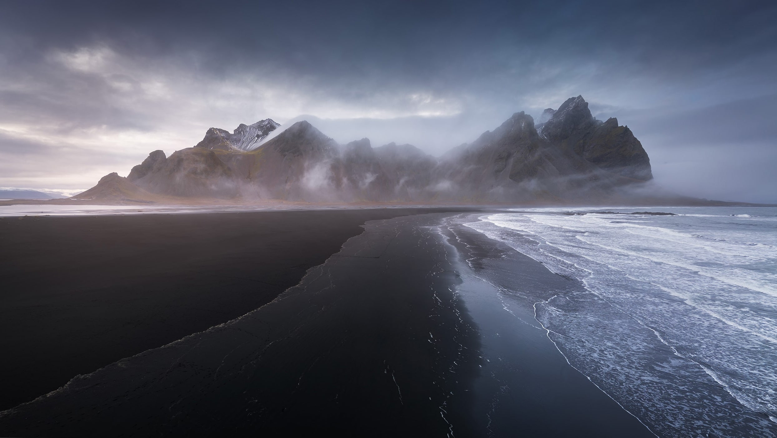 Aerial landscape view captured by drone of Stokksnes black sand beach and dramatic Icelandic coastline.