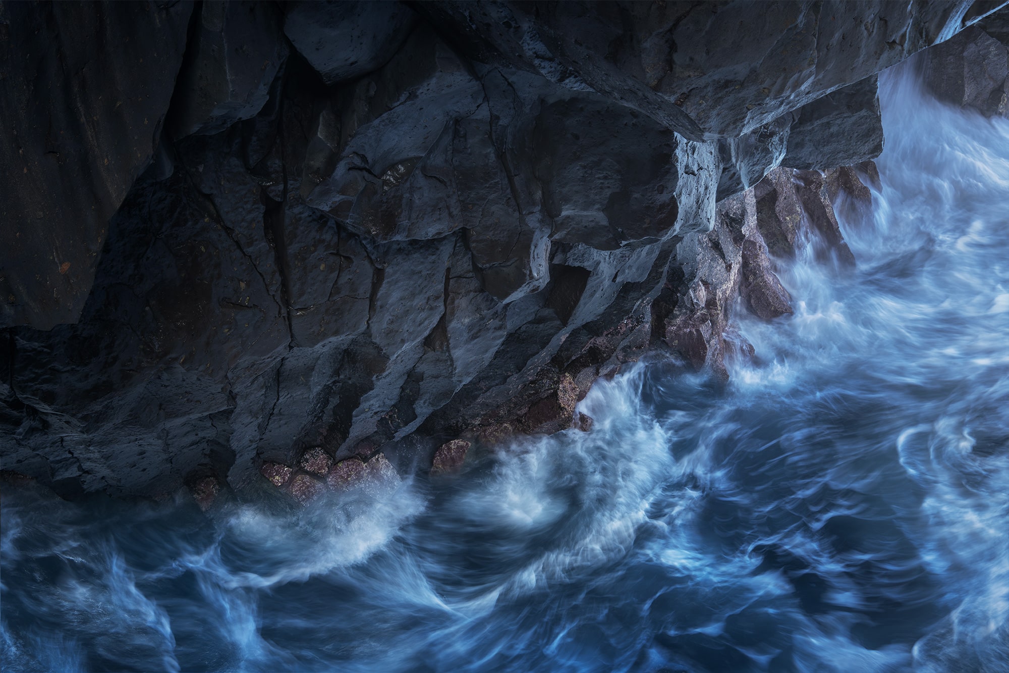 Long exposure photo of waves crashing into a sea cave at Los Hervideros, Lanzarote, Canary Islands. The scene shows black volcanic rocks and rough ocean during a windy day, captured with a Nikon Z8.