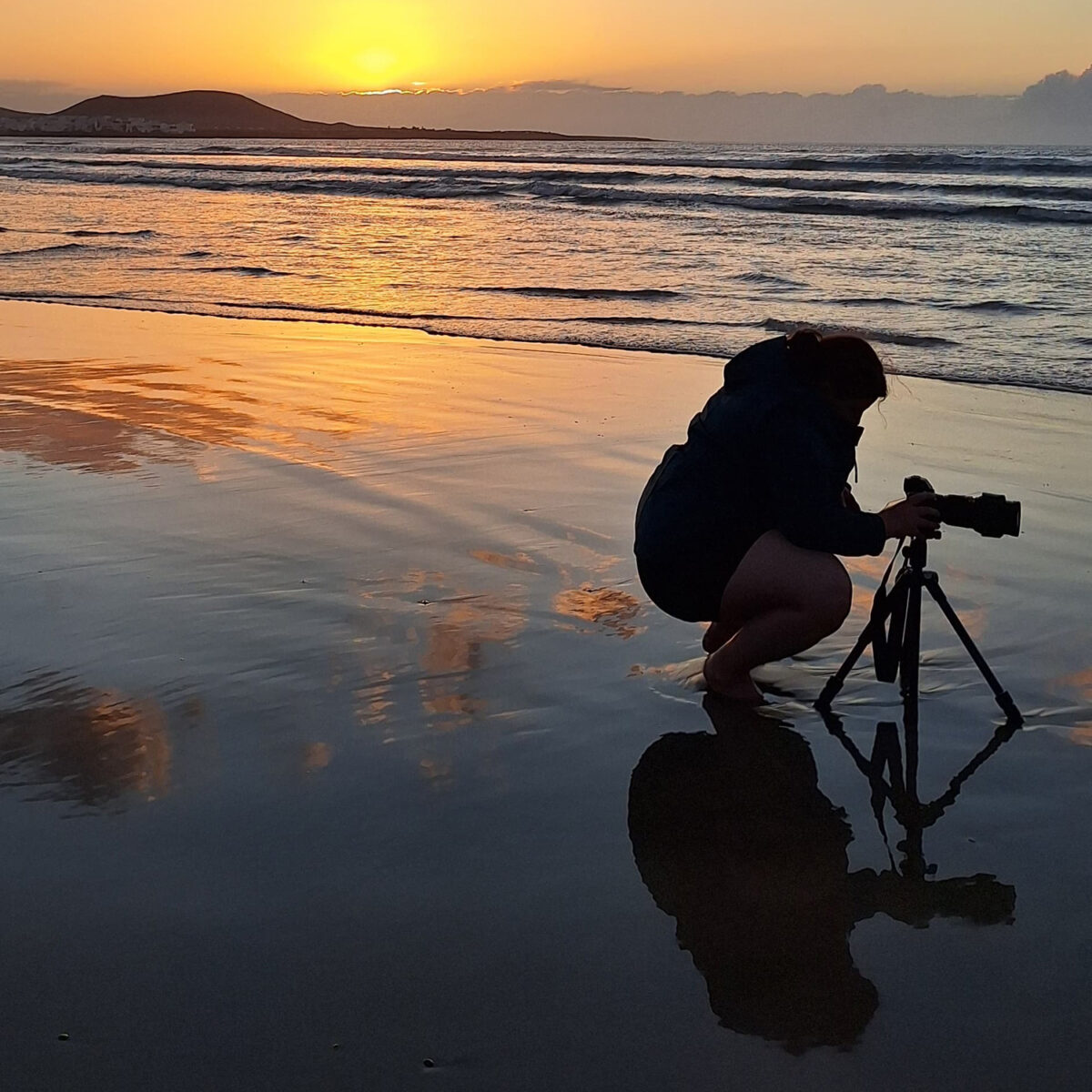 Behind the scene of Jennifer Esseiva taking a picture at Famara Beach in Lanzarote during sunset.