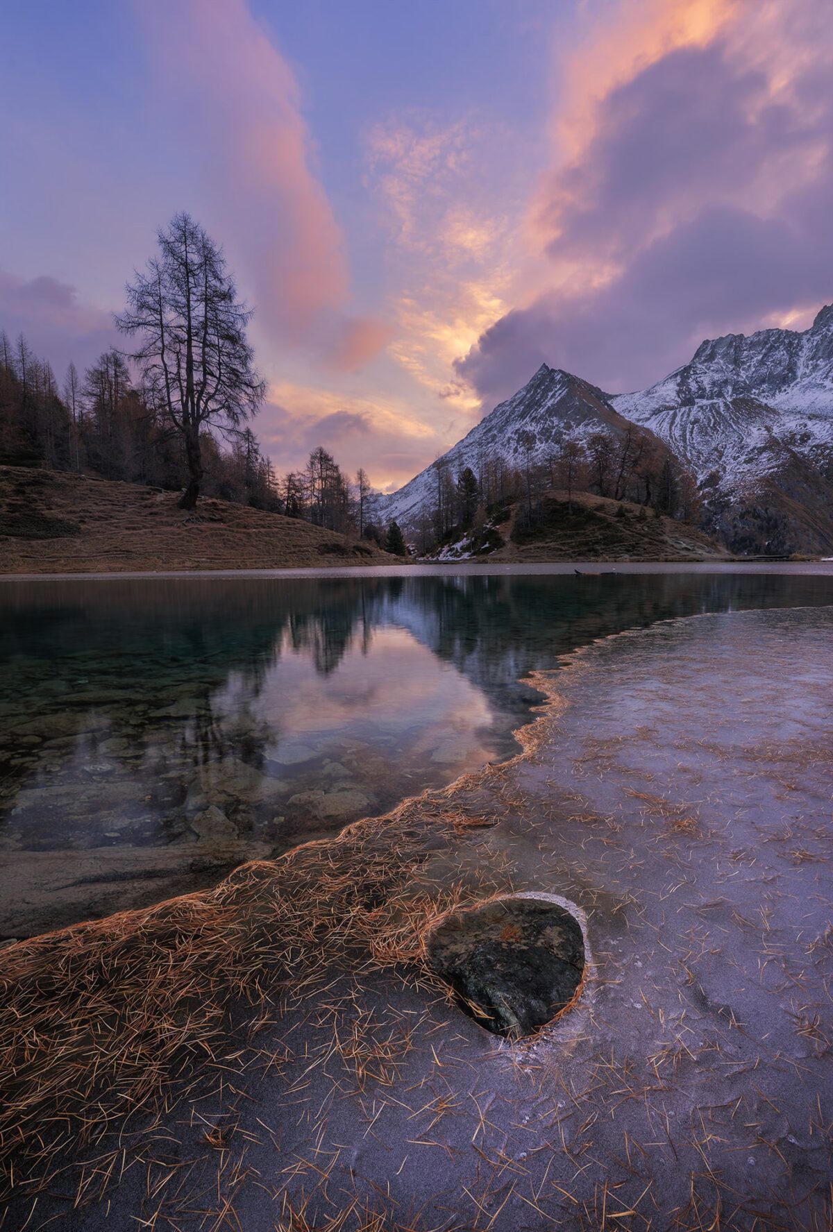 Sunrise fall landscape photography at Lac Bleu in Arolla, Canton of Valais, Switzerland. The scene captures the turquoise alpine lake surrounded by golden autumn colours in the Swiss Alps, showcasing the beauty of Arolla’s mountain landscape.