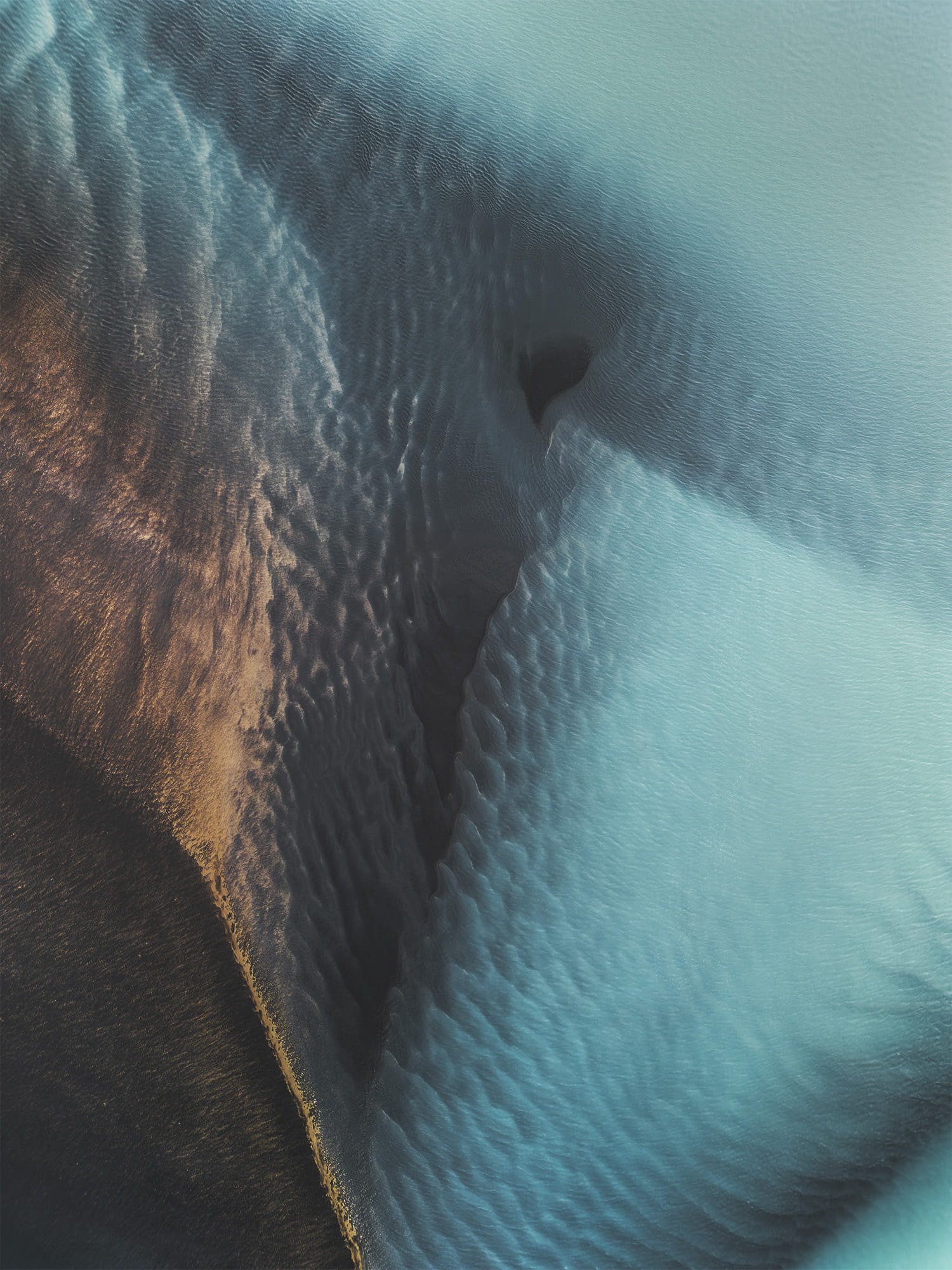 Aerial drone photography of braided river patterns near Selfoss, South Iceland, capturing a striking blue glacial river flowing across textured volcanic land.