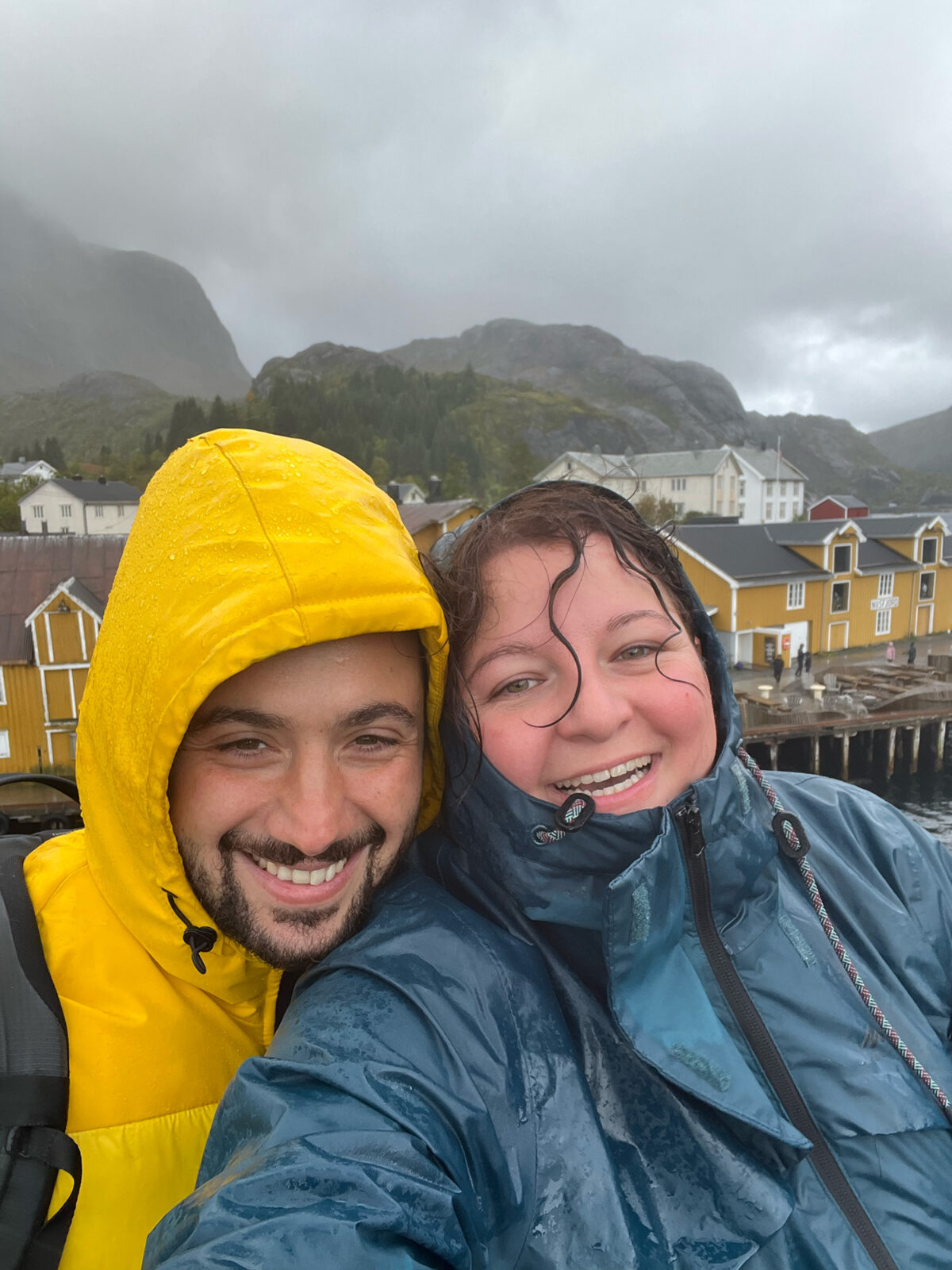Both of us smiling in the rain in Nusfjord, Lofoten Islands, Norway.