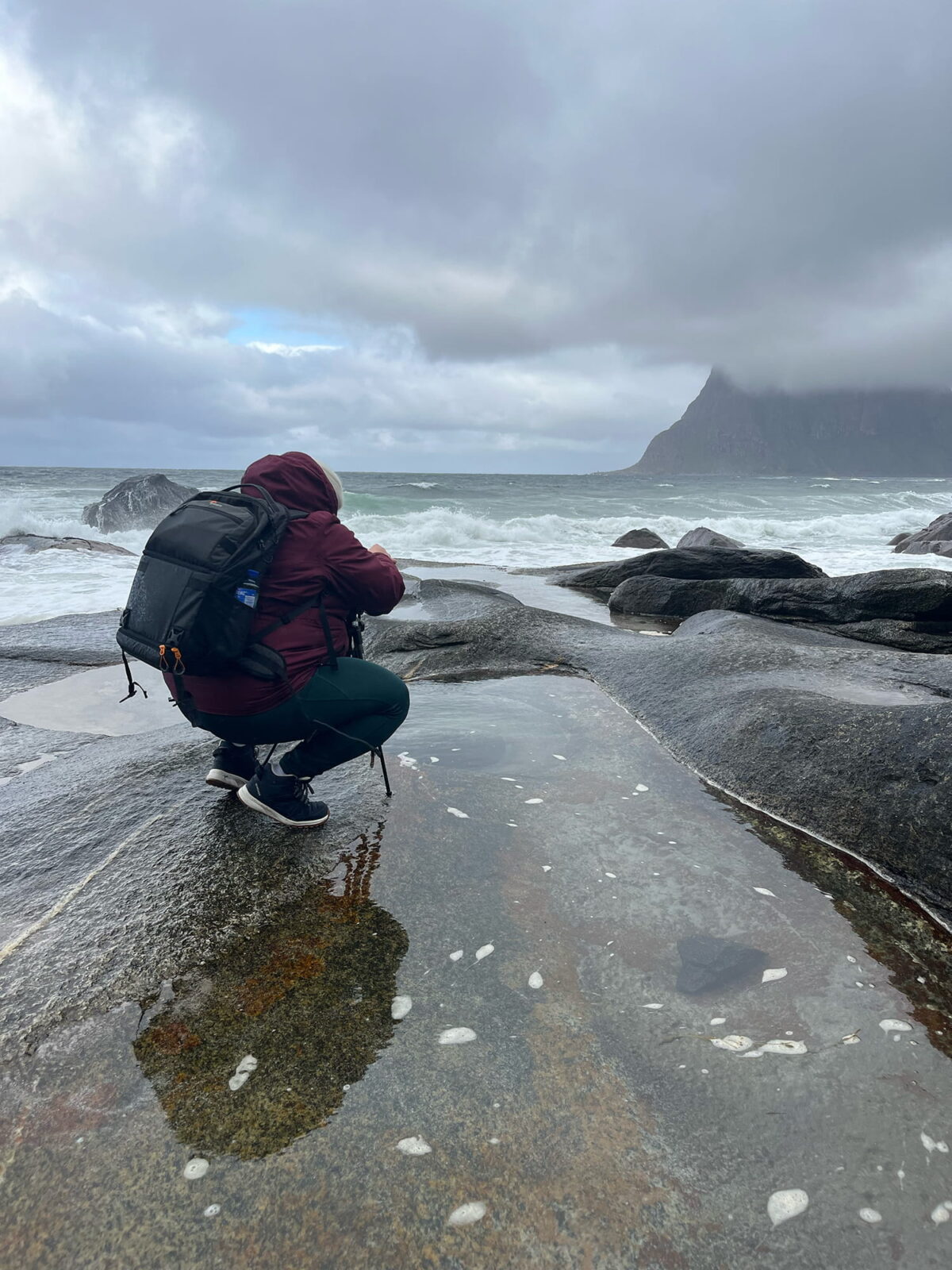 Swiss landscape photographer photographing the Dragon Eye at Uttakleiv Beach in stormy weather, Lofoten Islands, Norway