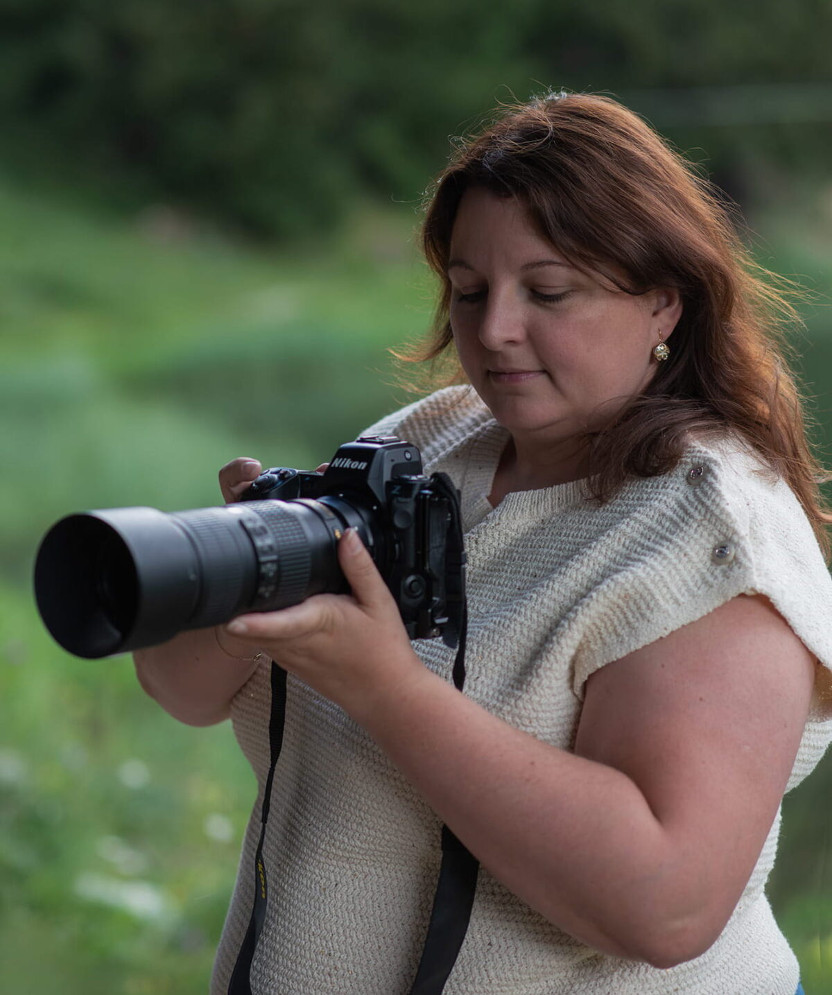 Swiss landscape photographer reviewing images on a Nikon Z8 with a Nikon 70-200mm telephoto lens during an outdoor photography session in the Swiss Alps.