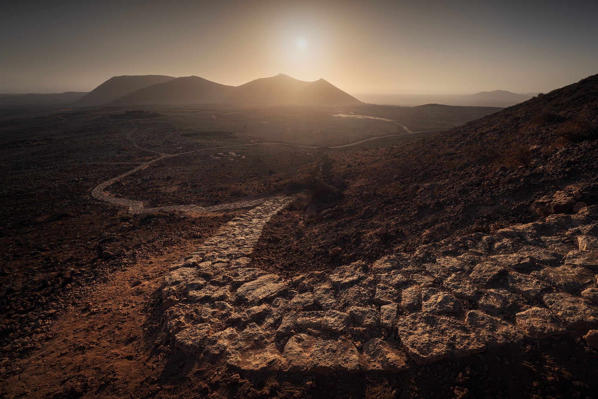 Sunrise landscape from the trail to Caldera de Hondo in Fuerteventura, Canary Islands, overlooking the volcanic peaks of Volcanes de Bayuyo and Caldera Rebanada.